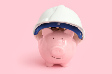 Piggy bank in hardhat on pink background