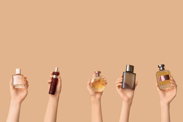 Female hands with many bottles of perfume on brown background