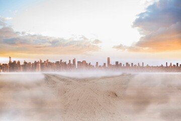 Sandy path leading to large urban city
