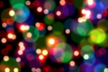 Multicolored blurred light circles are floating over black backdrop in digital bokeh pattern