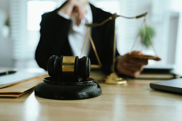 Lawyer sitting at desk in modern office reviewing and signing legal documents related to finance,...