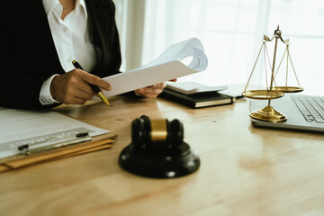 Lawyer sitting at desk in modern office reviewing and signing legal documents related to finance, equity and contractual agreements in business law.