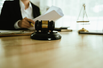 Lawyer sitting at desk in modern office reviewing and signing legal documents related to finance, equity and contractual agreements in business law.