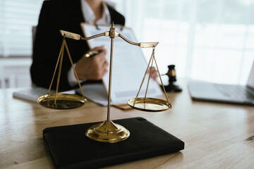 Lawyer sitting at desk in modern office reviewing and signing legal documents related to finance, equity and contractual agreements in business law.
