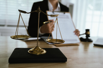 Lawyer sitting at desk in modern office reviewing and signing legal documents related to finance, equity and contractual agreements in business law.