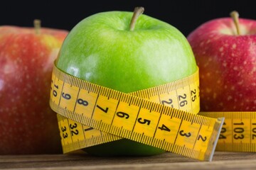 Red and green apples with measuring tape