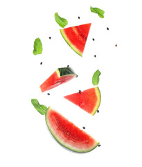Obraz na płótnie Canvas Flying pieces of fresh watermelon with mint and seeds on white background
