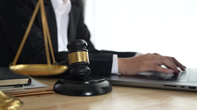 Lawyer sitting at desk in modern office reviewing and signing legal documents related to finance, equity and contractual agreements in business law.