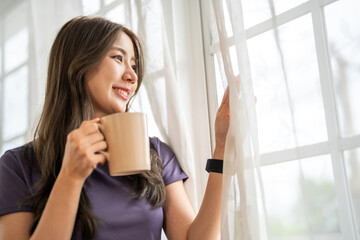 Portrait of smiling happy cheerful beauty pretty asian woman relaxing drinking and looking at cup...