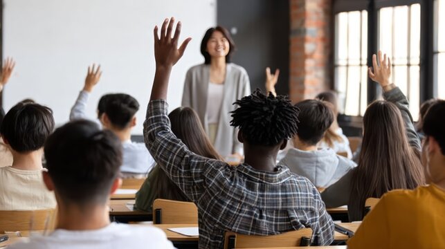 Diverse group of Gen Z Asian high school students in modern classroom, one Black male student raising hand to ask question to senior female teacher during interactive lecture - Powered by Adobe