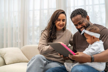 Obraz premium African love family happy time at home, father showing baby a tablet with cartoons for early childhood learning and development, mother smiling engaging in digital parenting and interactive education