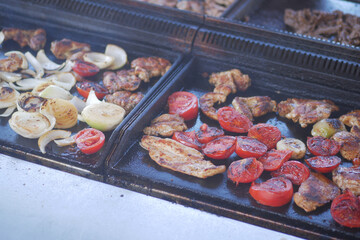 Grilled meats and vegetables on a hot cooking surface