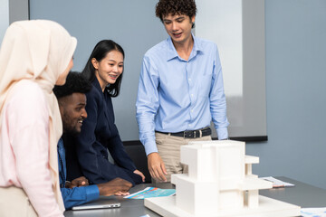 Architects engineers collaborating on building design project in modern office, diverse team of...