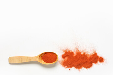 Wooden spoon with aromatic paprika powder on light background