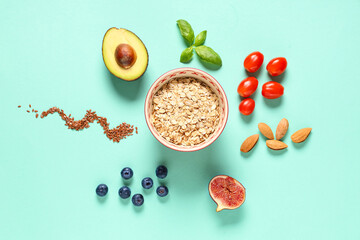 Tasty breakfast with oatmeal, fruits, vegetables and almond nuts on green background