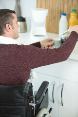 disable man in a wheelchair is making coffee