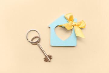 House figure with bow and key on beige background