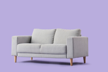Cozy grey sofa on purple background