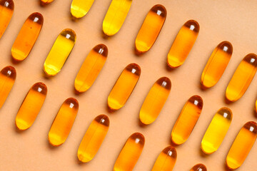 Composition with many fish oil capsules on color background, closeup