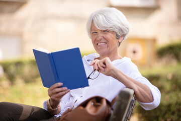 senior woman reading book in the park