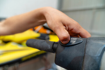 Mechanic pushing start button on machine handlebar