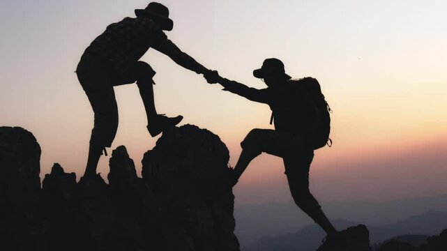 Silhouette of people climbers climb to the top overcoming hardships the path to victory. teamwork  help business travel  concept. group of tourists lends a helping hand climb the cliffs mountains.