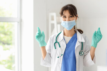 Female medical intern with mask and gloves in clinic