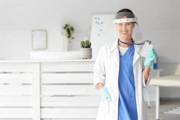 Female medical intern in protective mask with badge at hospital