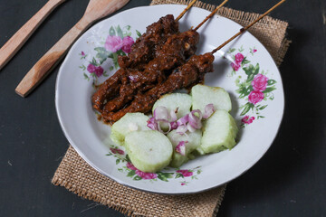 Indonesian traditional food chicken satay and lontong served on a glass plate