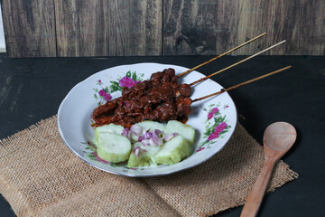 Indonesian traditional food chicken satay and lontong served on a glass plate