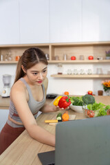 Wellness and Healthy Living. Young woman preparing fresh vegetables in a modern kitchen.
