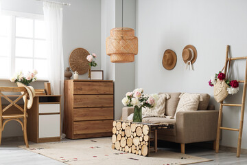 Interior of stylish living room with grey sofa, wooden coffee table and beautiful peonies