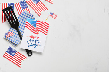 USA flags, greeting card with text HAPPY 4TH OF JULY and barbecue spatula on white grunge...