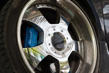 Car mechanic or serviceman disassembly and checking a disc brake and asbestos brake pads for fix...