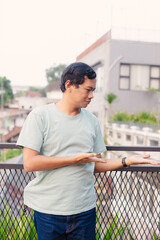 Man gesturing on a balcony overlooking a cityscape, showcasing a presentation concept outdoors