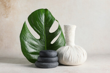 Composition with spa stones, tropical leaf and herbal bag on white grunge background, closeup