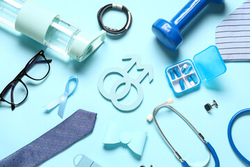 Male signs with ribbon, pills and male accessories on blue background. Prostate cancer awareness...