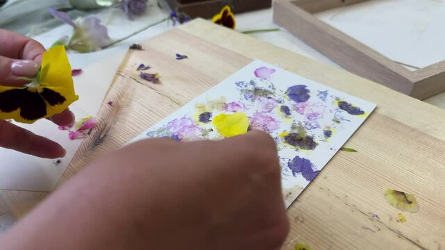 Finished floral print made with real petals and hammering technique &ndash; botanical art on paper, surrounded by craft tools and flower remnants