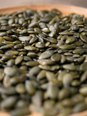 Obraz premium Peeled dry pepita pumpkin seeds background.