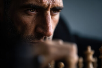 dynamic portrait of chess player captured in left part of frame showing concentrated expression as they ponder