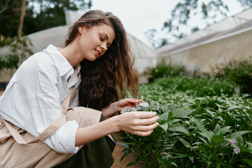 Young woman caring for plants in a serene garden, showcasing a passion for gardening and nature,...