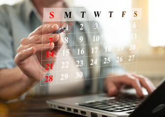 Planning events and deadlines using a digital calendar on a laptop in a well-lit workspace