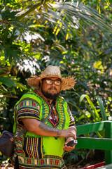 Local man with straw hat and colorful Caribbean shirt looking at the camera in Cahuita National Park, Costa Rica