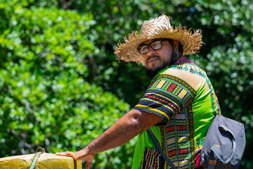 Local man with straw hat and colorful Caribbean shirt enjoying Costa Rica's tropical climate