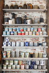Ceramic products such as vases, glass bottles, teapots, placed on shelves