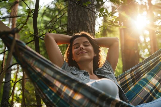 Young woman relaxing in hammock enjoying sunset in forest