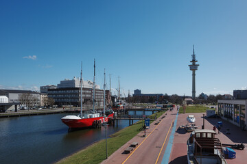 Fototapeta premium An elevated view of the Museum Harbor in Bremerhaven, Germany, taken from the historic tugboat 'Stier'. The red museum lightship 'Elbe 3' is moored at the dock. 