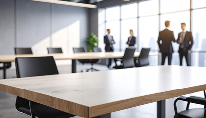 Close-up of a wide conference desk against a blurry modern bright office with worker background.