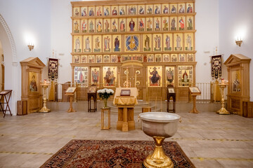 Cross and candle in an Orthodox church. Interior of an Orthodox church, with a cross and baptismal...