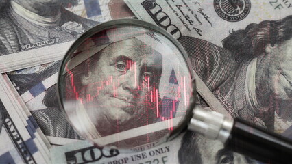 red downward arrow inside a magnifying glass placed over a U.S. dollar banknote symbolizes economic decline, financial crisis, or recession in the United States.